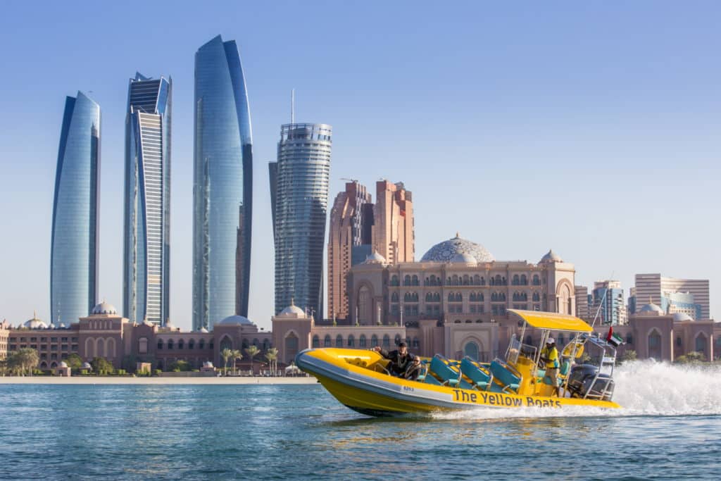 1-TYB-Sightseeing-Tour-Abu-Dhabi-Emirates-Palace-1024×683 a small boat in a body of water with a city in the background