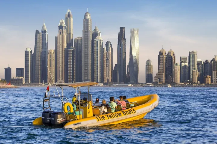 a small boat in a body of water with a city in the background