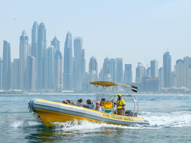 a small boat in a body of water with a city in the background
