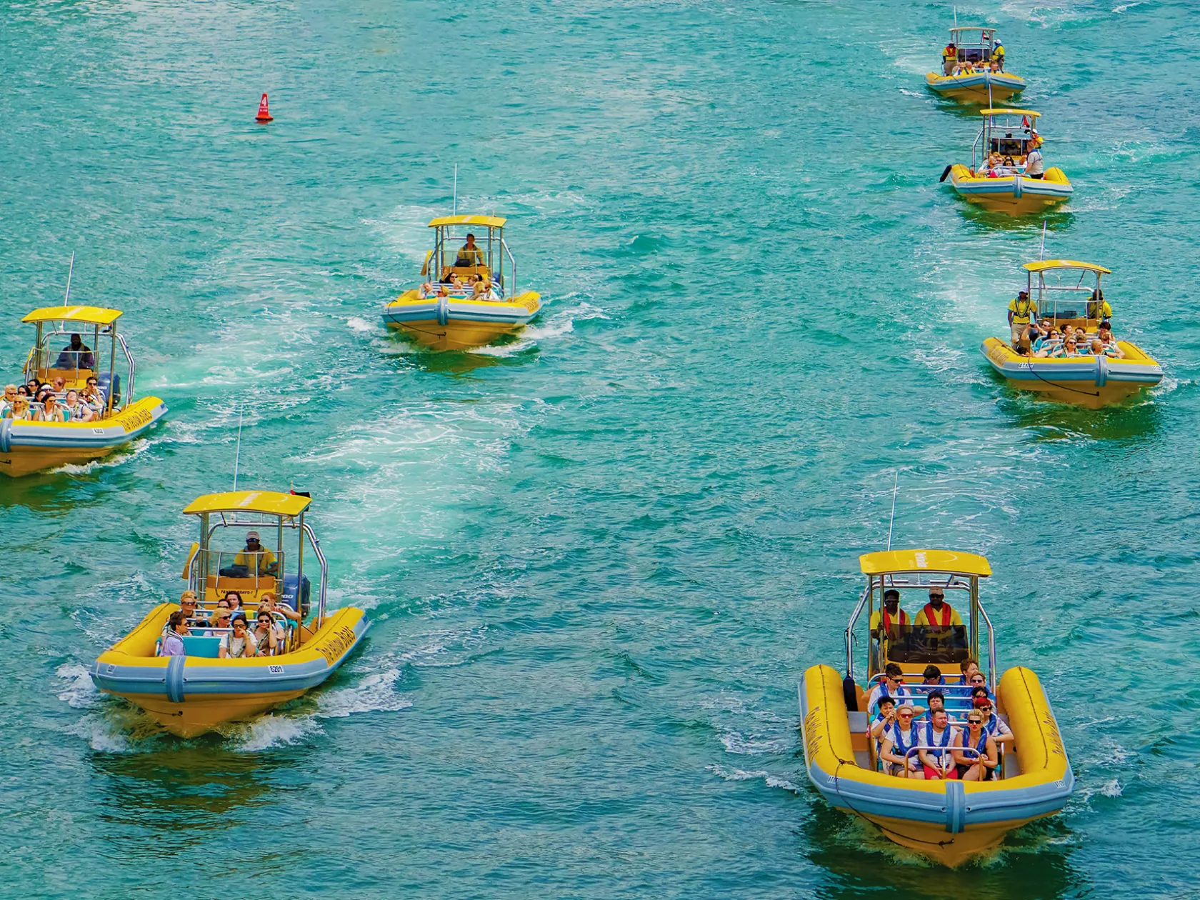 a group of people riding on the back of a boat in the water