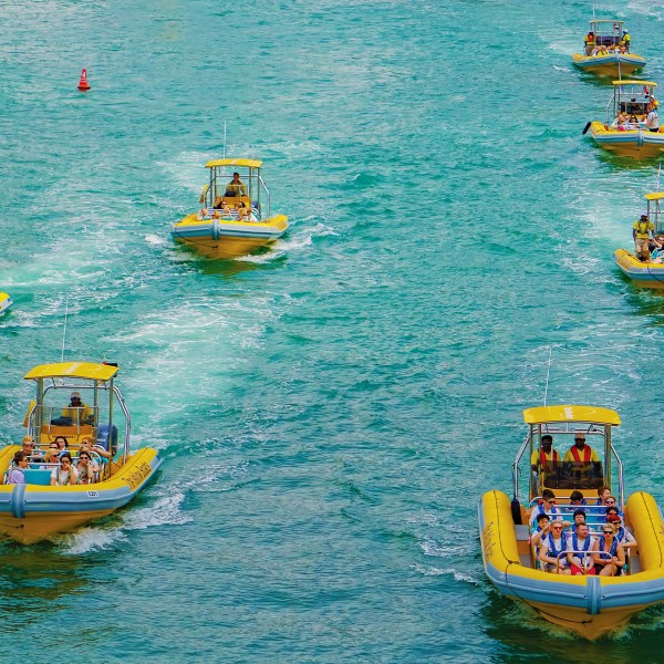 a group of people riding on the back of a boat in the water