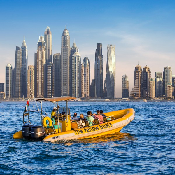 a small boat in a body of water with a city in the background